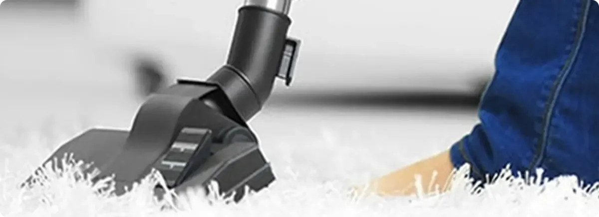 Close-up of a professional vacuuming a white carpet in Fountain Hills.